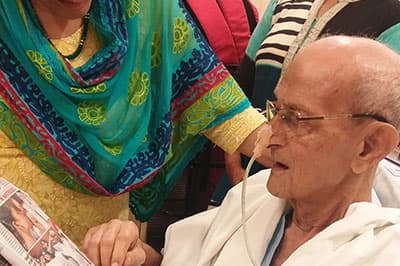An elderly patient listens closely as a clinician speaks beside him
