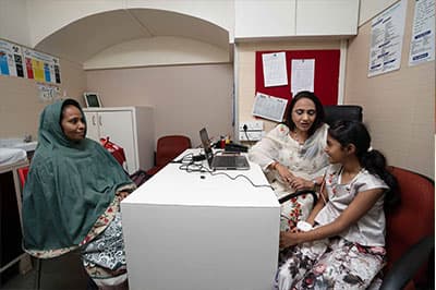 A clinician works with a mother and daughter at Shaba