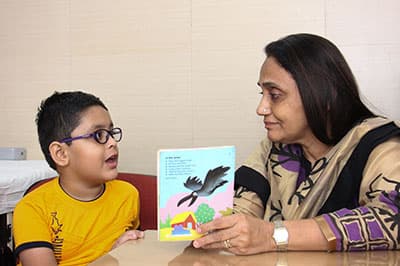 A therapist holds up a picture book for a boy