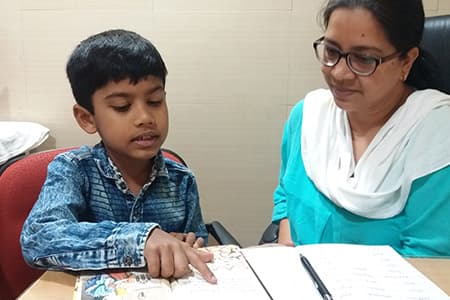 A therapist works through a workbook with a boy