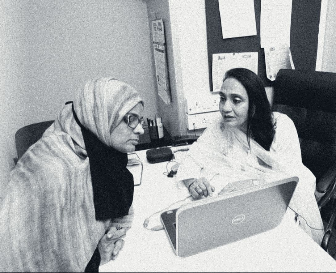 A clinician talks a parent through results on a laptop during a counselling session at Shaba